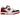 New Balance 550 White Red Black baskets profil, dotées d'une empeigne en cuir blanc, de détails rouges au talon, d'une semelle et logo noirs