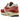 Nike Air Max 1 Red Stardust baskets en vue inclinée avec unité Air visible, empeigne beige, semelle intermédiaire blanche et détails roses